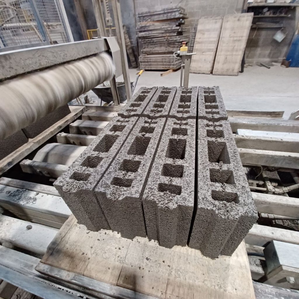 Een machine in een fabriek produceert recyclebare betonblokken.