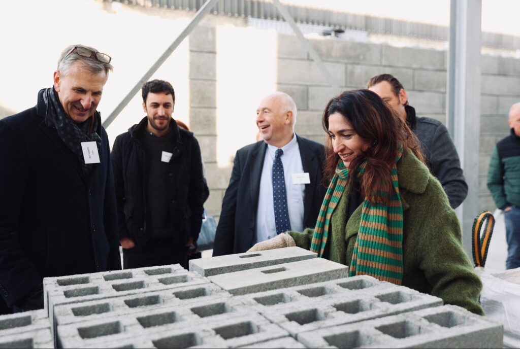 Een groep mensen rond duurzame en kosteneffectieve betonblokken.