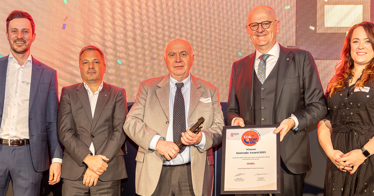 A group of people posing for a picture with an award.